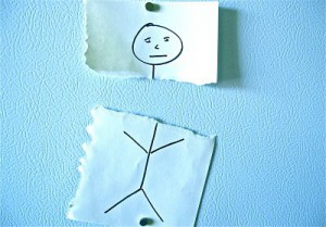 Photo of a stick figure that is drawn on paper and has its head torn off