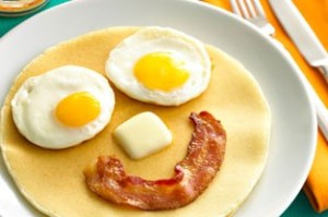 Eggs, bacon and pancakes arranged in a smiley face