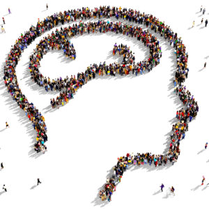 social determinants of mental health - Large group of people seen from above gathered together in the shape of a human head with brain 