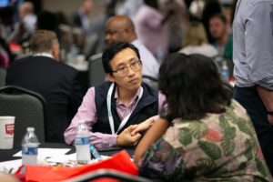 A a man in discussion with other attendees during the 2019 Robert Lee Sutherland Seminar