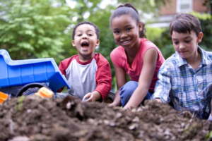 3 kids playing in the dirt