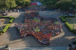 A photo of a large group of people standing in the shape of Texas.