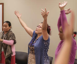 3 women raising their arms in worship