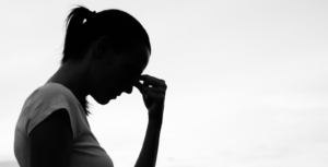 A stock photo of a woman's silhouette with her hand to her face.