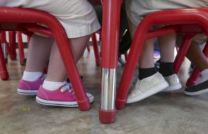 A photo of students feet sitting at a table