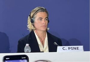 Viral image of actor Chris Pine, sitting at a press conference with headphones on.