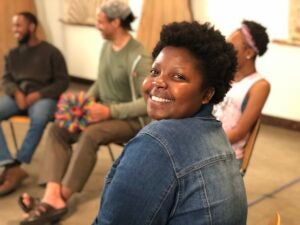 Smiling black woman, looking over shoulder.