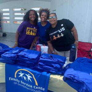 The Future is US parent and youth at volunteer table with t-shirts.
