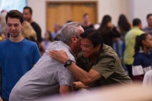 Two men hugging and shaking hands.